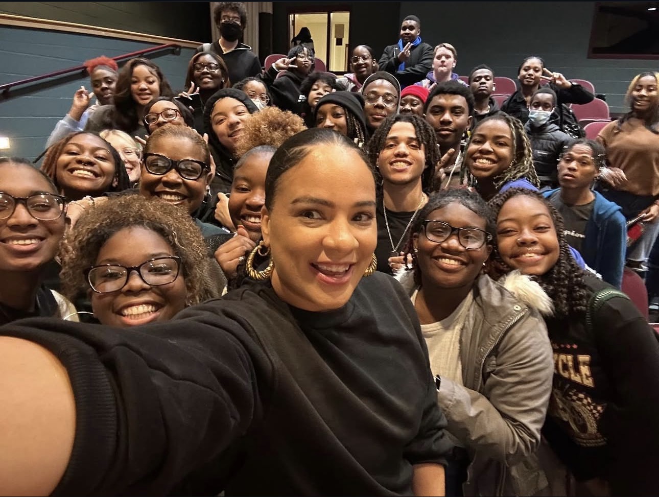 Maia Chaka taking a selfie with a large group of high school students at Kingsfork High School